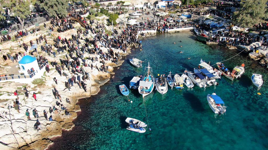 Piraeus, Attica / Greece - January 6 2019: Aerial drone photo of famous Christian ceremony of Epiphany in small port of Aphrodite, with iconic small chapel of Agios Nikolaos