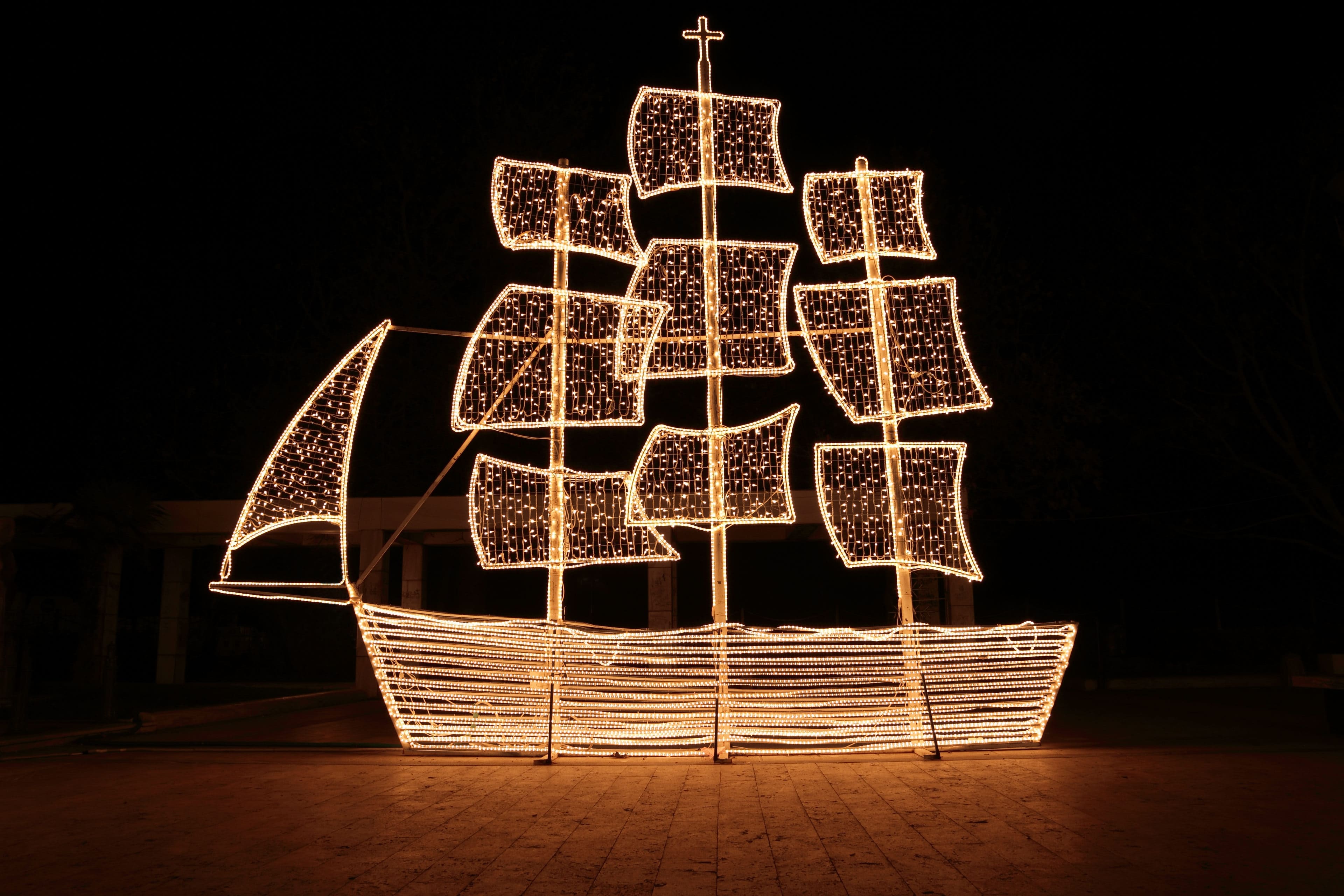 A Christmas tree stands in a dinghy at night