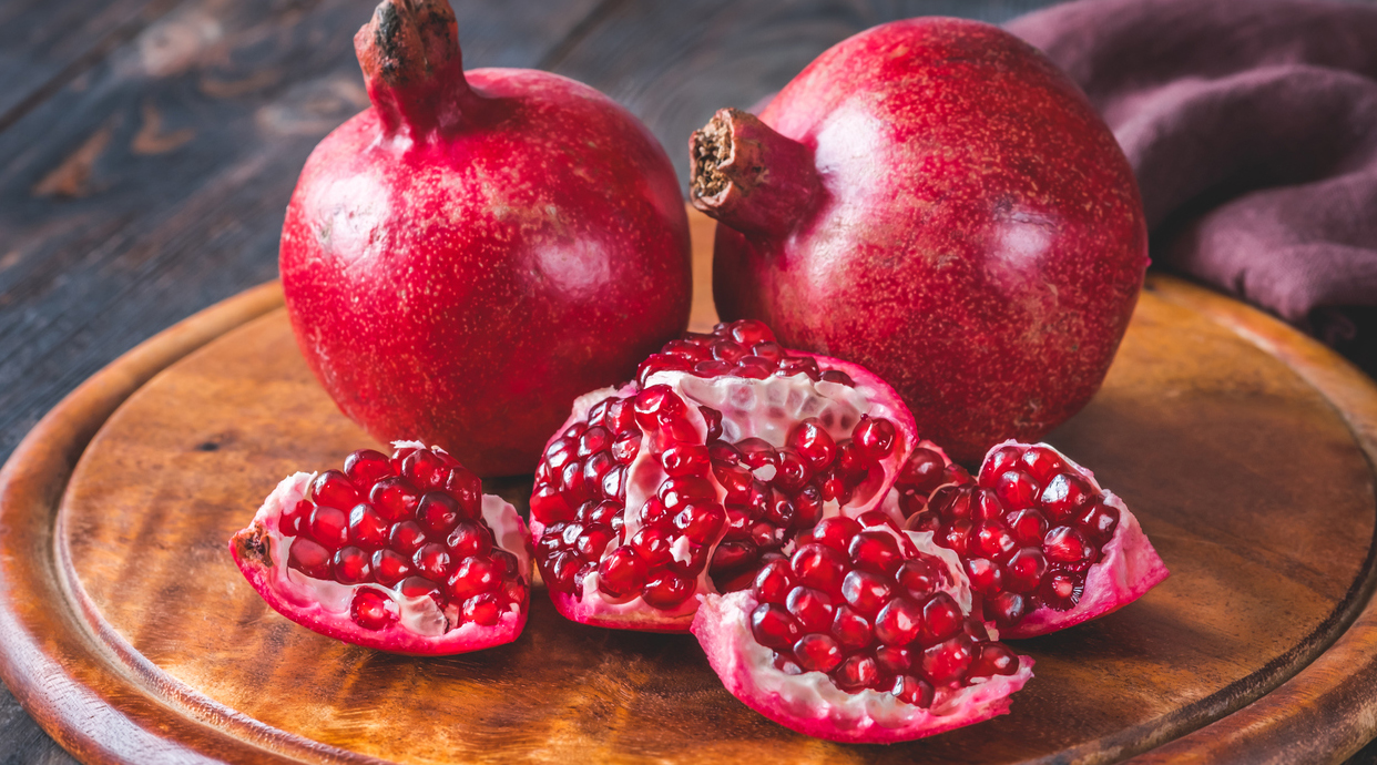 Fresh pomegranates on the wooden table: flat lay